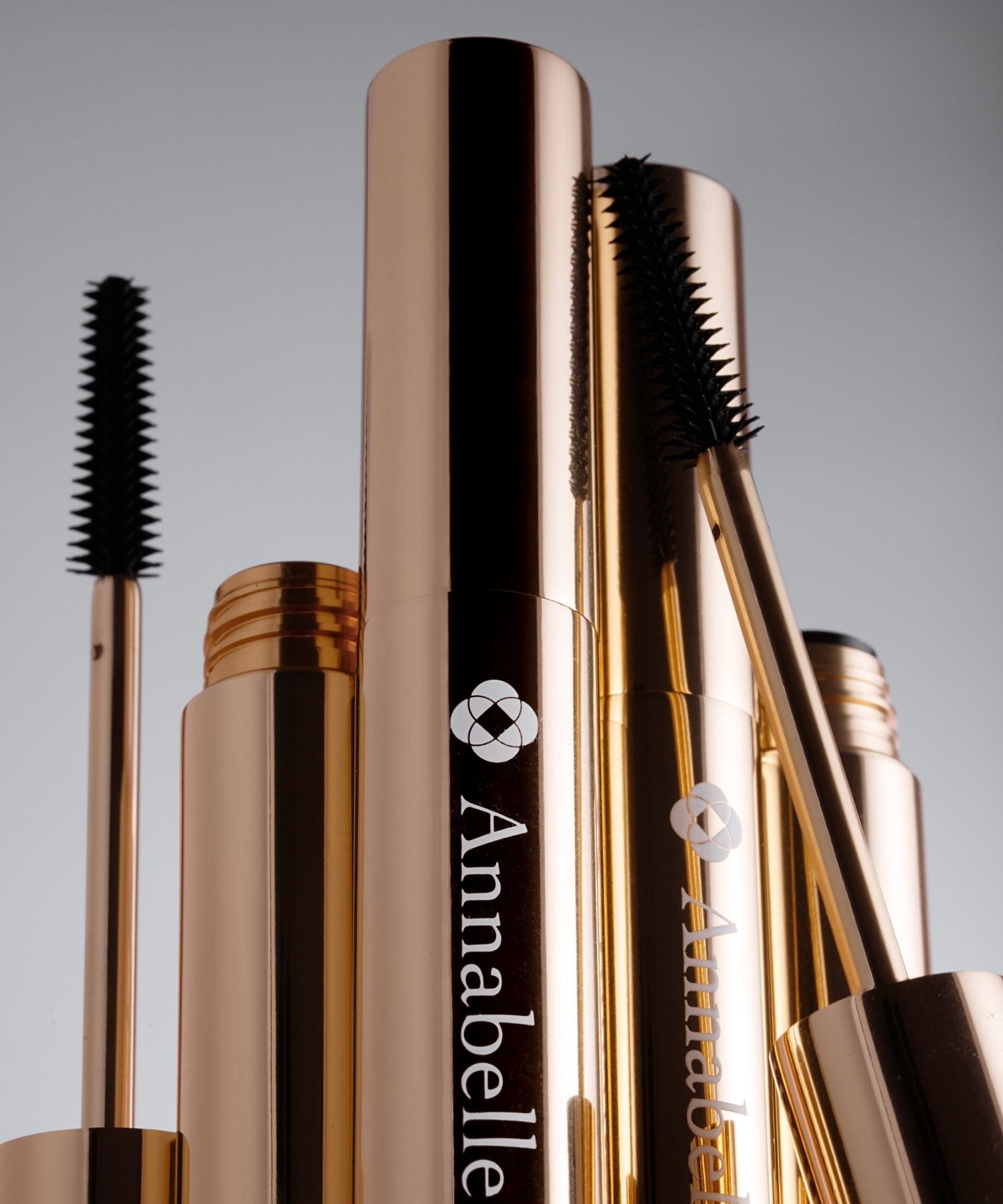 Tuby maskary Annabelle Minerals w złotym kolorze z widocznymi szczoteczkami do aplikacji