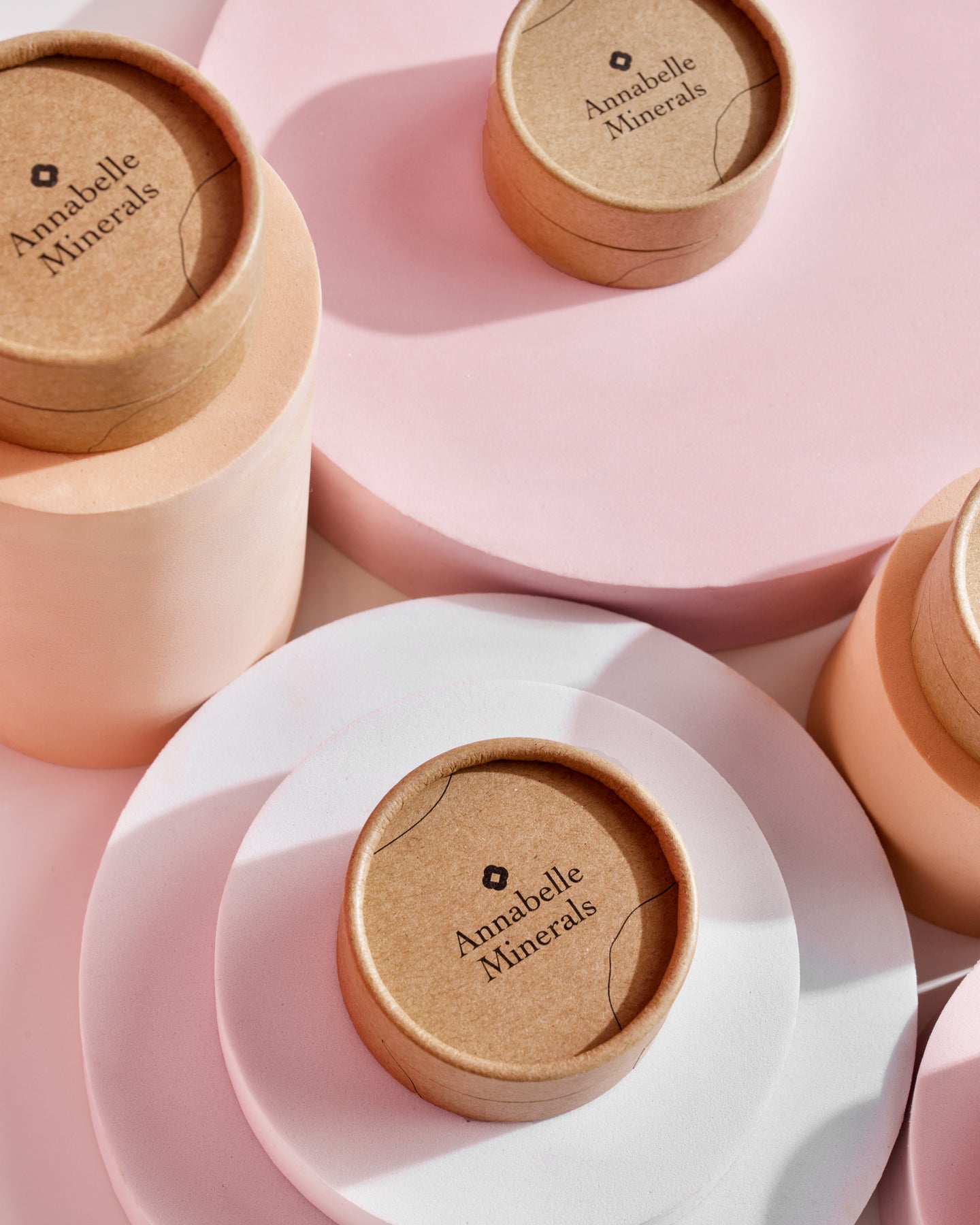 Papierowe pojemniki w pastelowych kolorach na kosmetyki, z minimalistycznym designem i etykietą Annabelle Minerals
