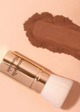 Podróżnych wysuwany pędzel flat top Annabelle Minerals, obok swatch koloru na neutralnym tle